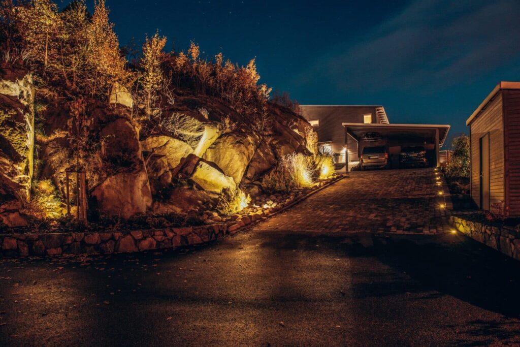 Europaljus - Ett upplyst hus på natten framför en bergvägg, Elbesparing är viktigt.