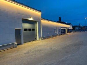 Europaljus - En vit byggnad med en parkeringsplats på natten