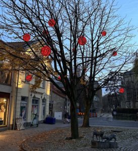 Europaljus - Ett träd prydt med röda kulor hängande från det.
