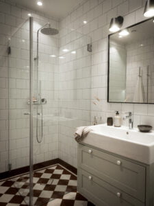 Europaljus - Ett badrum med duschkabin i glas och snygg belysning.