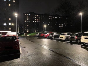 Europaljus - En parkeringsplats med bilar parkerade på natten, upplyst av gatuljus.